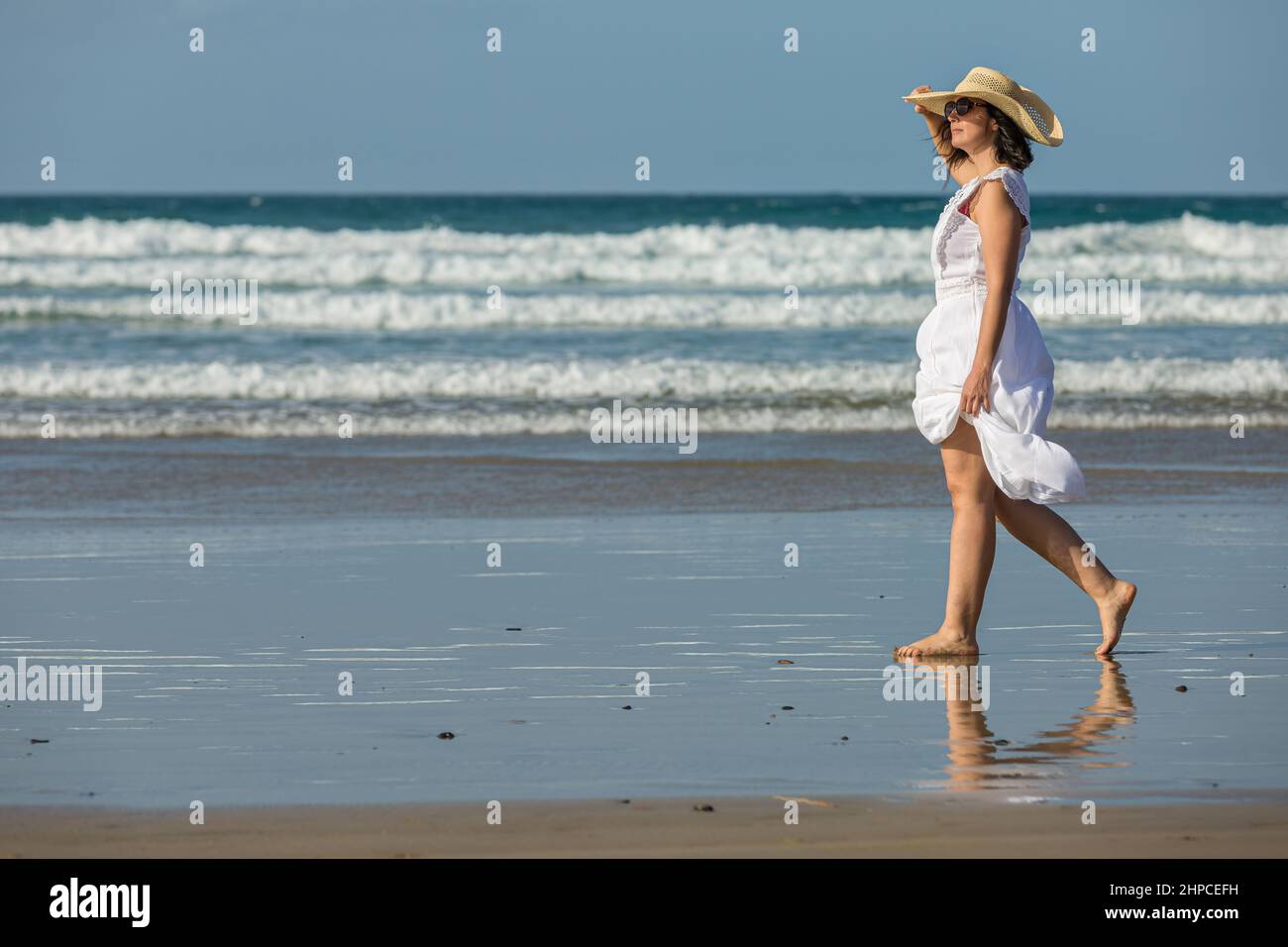 Frau, die am Meer spazieren ging und den Strand bewunderte Stockfoto