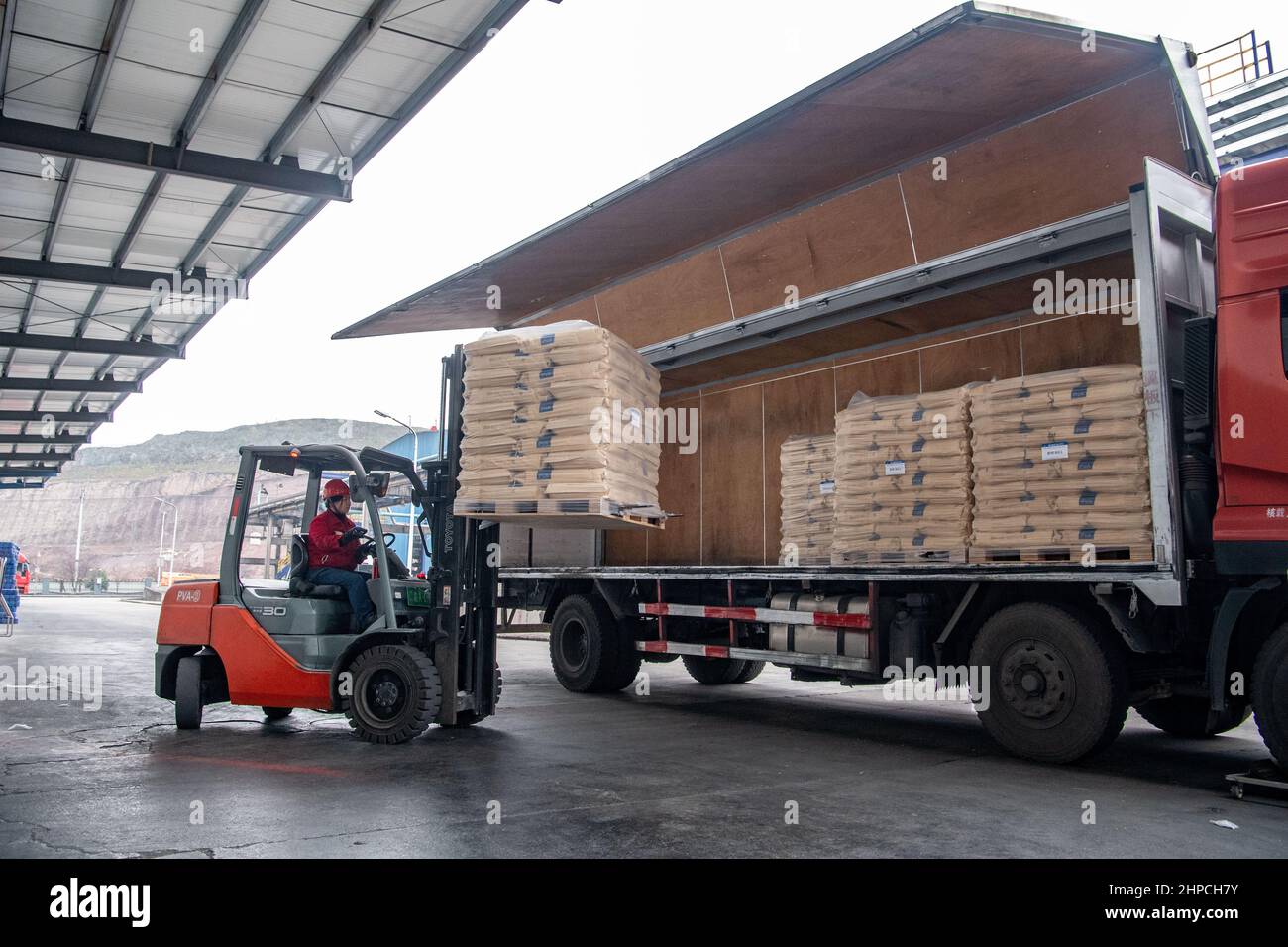 Chongqing, China. 12th. Februar 2022. Ein Mitarbeiter lädt Pakete mit Polyvinylalkohol (PVA)-Produkten auf einen LKW in Chongqing, Südwestchina, 12. Februar 2022. Ein Yuxin'ou (Chongqing-Xinjiang-Europa) China-Europa-Güterzug mit mehr als 1.100 Tonnen Polyvinylalkohol (PVA) und anderen feinchemischen Produkten verließ den Hafen Guoyuan in Chongqing und fuhr am 20. Februar nach Duisburg. Quelle: Tang Yi/Xinhua/Alamy Live News Stockfoto