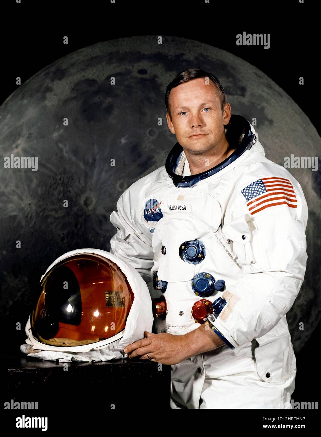 Offizielles NASA-Porträt des Astronauten Neil A. Armstrong, Kommandeur der Apollo 11 Lunar Landing-Mission in seinem Weltraumanzug, mit seinem Helm auf dem Tisch vor ihm. Hinter ihm ist ein großes Foto der Mondoberfläche. Das Foto wurde am 1. Juli 1969 aufgenommen; Apollo 11 startete am 16. Juli und war der Weltraumflug, bei dem die Menschen zum ersten Mal auf dem Mond landeten. Stockfoto
