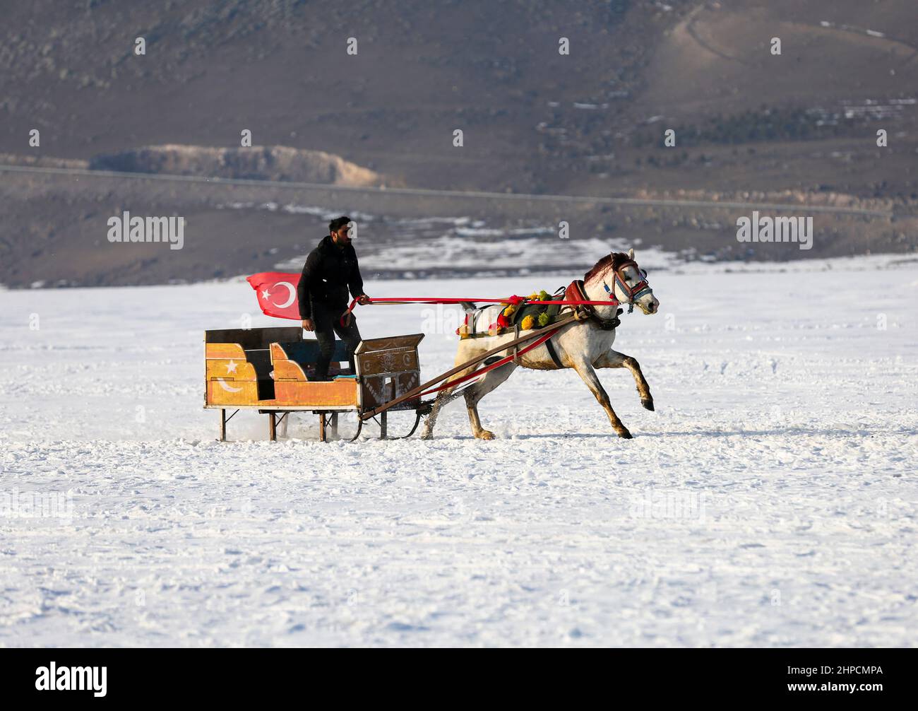 Kars, Istanbul, Türkei. 19th. Februar 2022. Der Cildir-See im Nordosten der Türkei zieht das ganze Jahr über und vor allem im Winter Touristen an.der Cildir-See liegt zwischen den türkischen Provinzen Kars und Ardahan in der Region Ostanatolien und ist ein beliebter Ort für den Wintertourismus in der Türkei sowohl für einheimische als auch für ausländische Touristen. Von Pferden gezogene Schlitten reiten Touristen über den zugefrorenen See. Andere Touristen schwelgen beim Eisfischen. (Bild: © Serkan Senturk/ZUMA Press Wire) Stockfoto