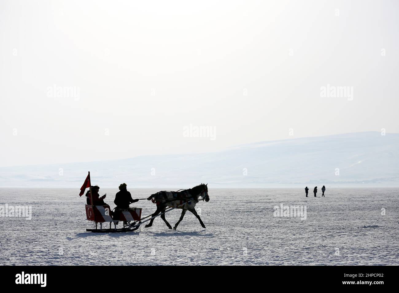 Kars, Istanbul, Türkei. 19th. Februar 2022. Der Cildir-See im Nordosten der Türkei zieht das ganze Jahr über und vor allem im Winter Touristen an.der Cildir-See liegt zwischen den türkischen Provinzen Kars und Ardahan in der Region Ostanatolien und ist ein beliebter Ort für den Wintertourismus in der Türkei sowohl für einheimische als auch für ausländische Touristen. Von Pferden gezogene Schlitten reiten Touristen über den zugefrorenen See. Andere Touristen schwelgen beim Eisfischen. (Bild: © Serkan Senturk/ZUMA Press Wire) Stockfoto