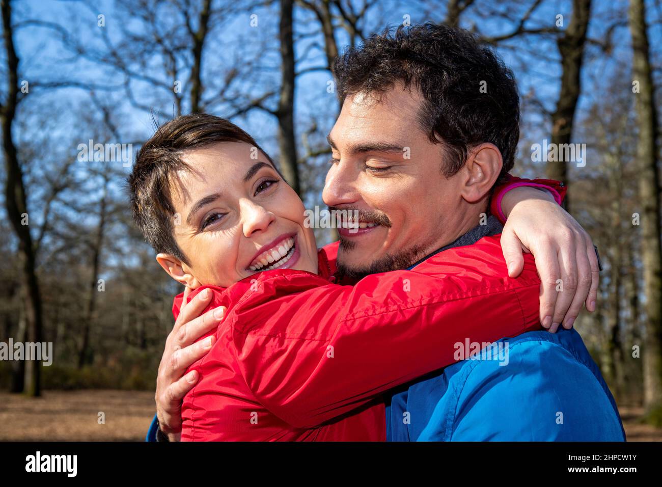 Das junge Paar umarmt sich glücklich im Wald. Schönes Paar haben Spaß beim Wandern in den Wäldern in Italien. Stockfoto