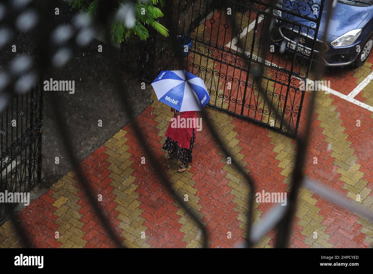 Mumbai; Maharashtra; Indien- Asien, Juni, 2019 : verschwommenes Bild, Luftansicht, Frau, die bei starkem Regen einen Regenschirm über dem Kopf hält. Stockfoto