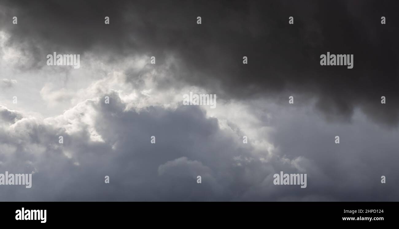 Bewölkt, Gewitterwolken am Himmel teilweise von der Sonne beleuchtet Stockfoto