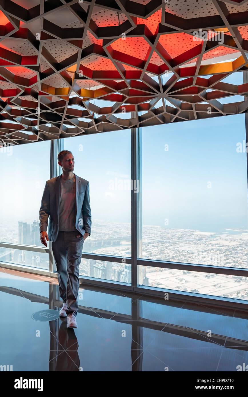 Junger Mann, der Dubai vom Wolkenkratzer Burj Khalifa aus erkundet. Stockfoto