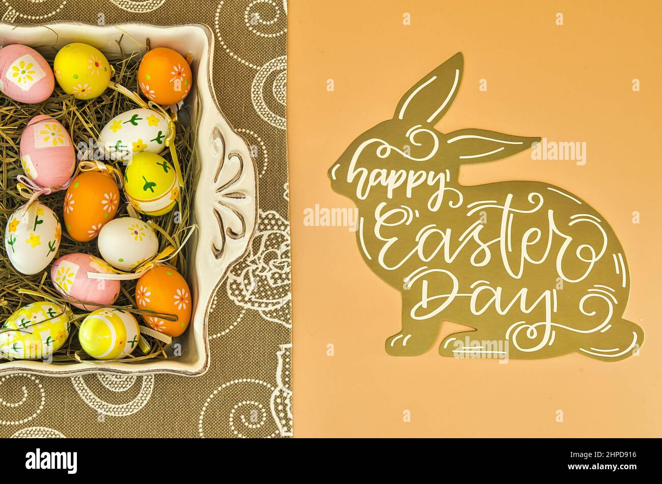 Osterhintergrund mit bemalten ostereiern und Kaninchen wünschend Frohe Ostern. Stockfoto