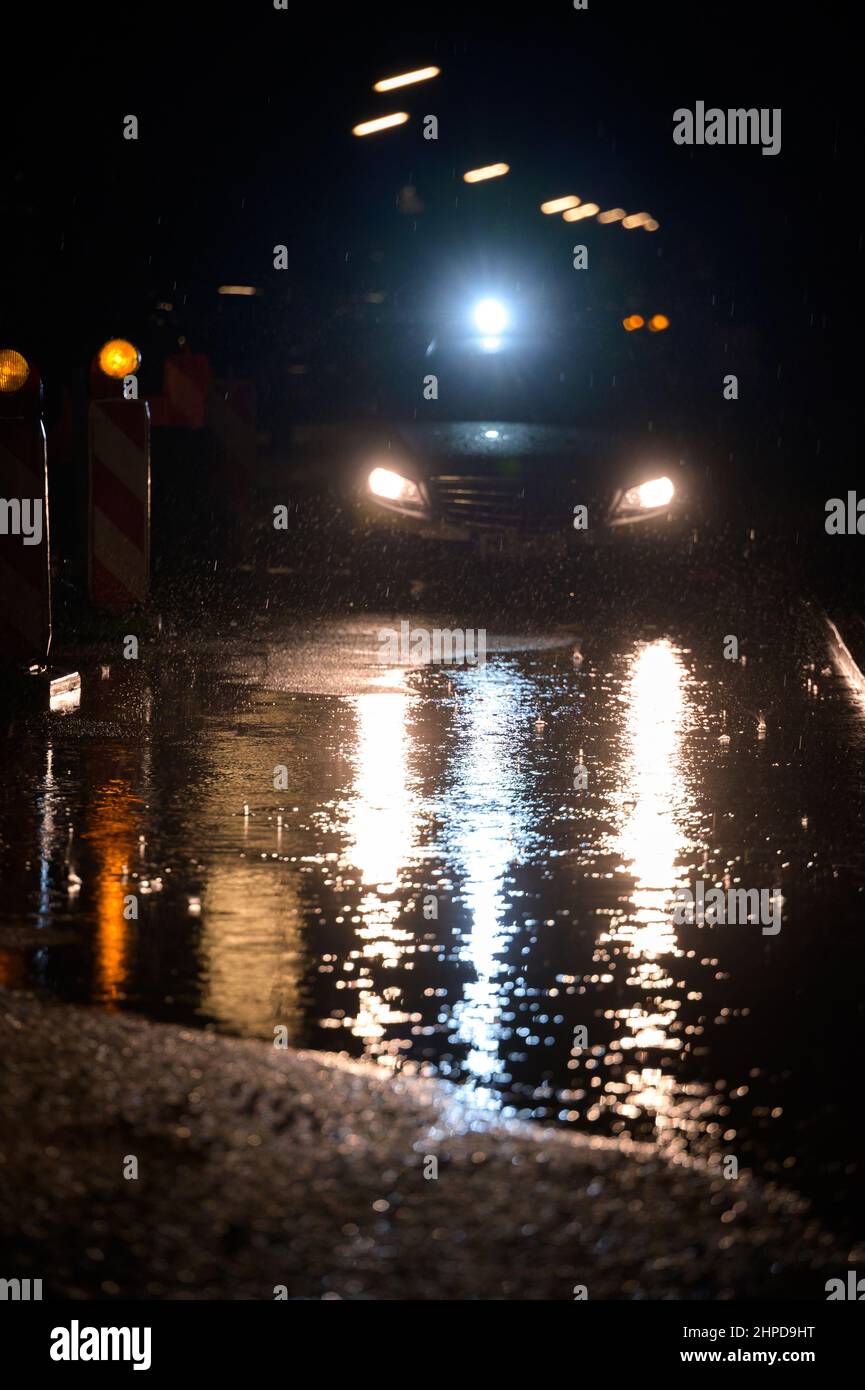 Hamburg, Deutschland. 20th. Februar 2022. Ein Streifenwagen beleuchtet eine große Pfütze auf einer Straße, deren Wasser nicht abfliessend ist. Zuerst 'Ylenia', dann 'Zeynep' und jetzt 'Antonia': Die Serie von schweren Stürmen hält vorerst nicht auf. Quelle: Jonas Walzberg/dpa/Alamy Live News Stockfoto