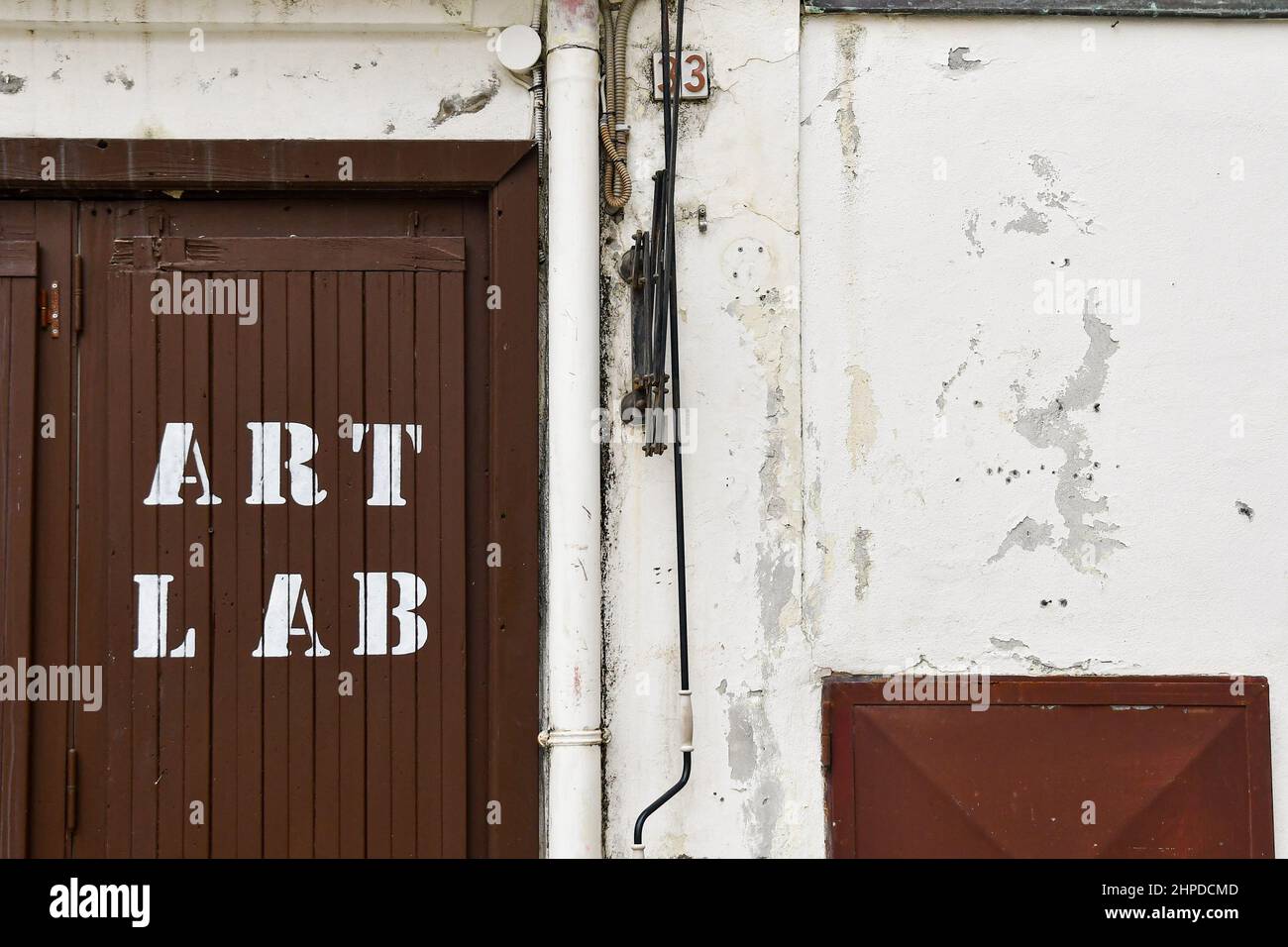 Außenansicht eines künstlerischen Labors mit dem Schild "Art Lab" auf der hölzernen Eingangstür eines alten Gebäudes, Sanremo, Imperia, Ligurien, Italien Stockfoto