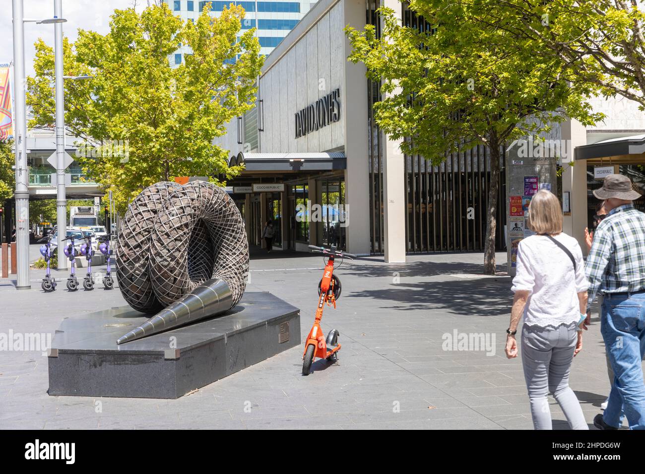Life Cycle öffentliche moderne Skulptur im Stadtzentrum von Canberra, in der Nähe geparkter E-Scooter und David Jones-Laden im Zentrum von Canberra, ACT, Australien Stockfoto