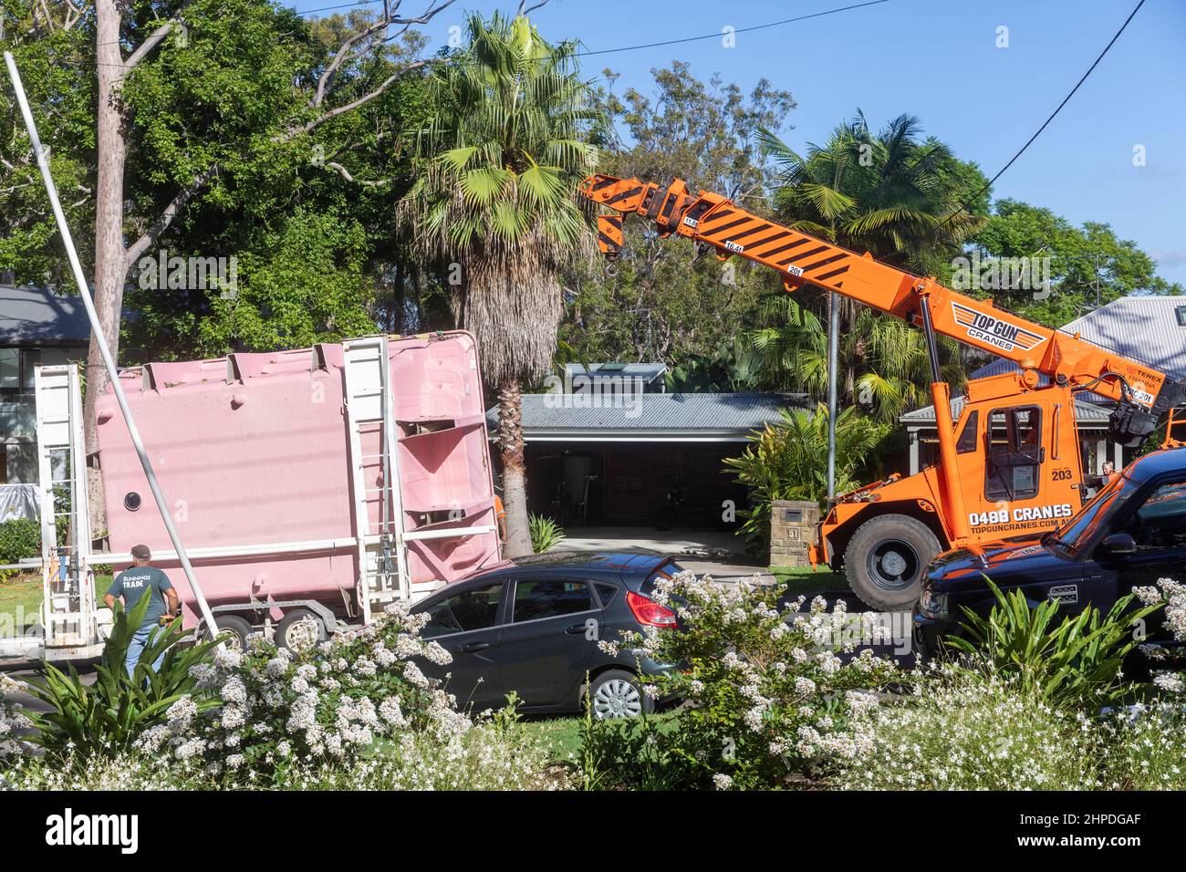 Die Fiberglas-Schwimmbadschale wird von einem mobilen Kran entladen, der bereit ist, sie in einem Haus in North Sydney, Sydney, NSW, Australien zu installieren Stockfoto
