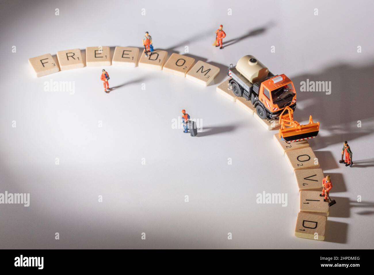 Miniaturfiguren, die die COVID-Straße reinigen, die Straße des Freiheitstages, die nach ihnen erscheint Stockfoto