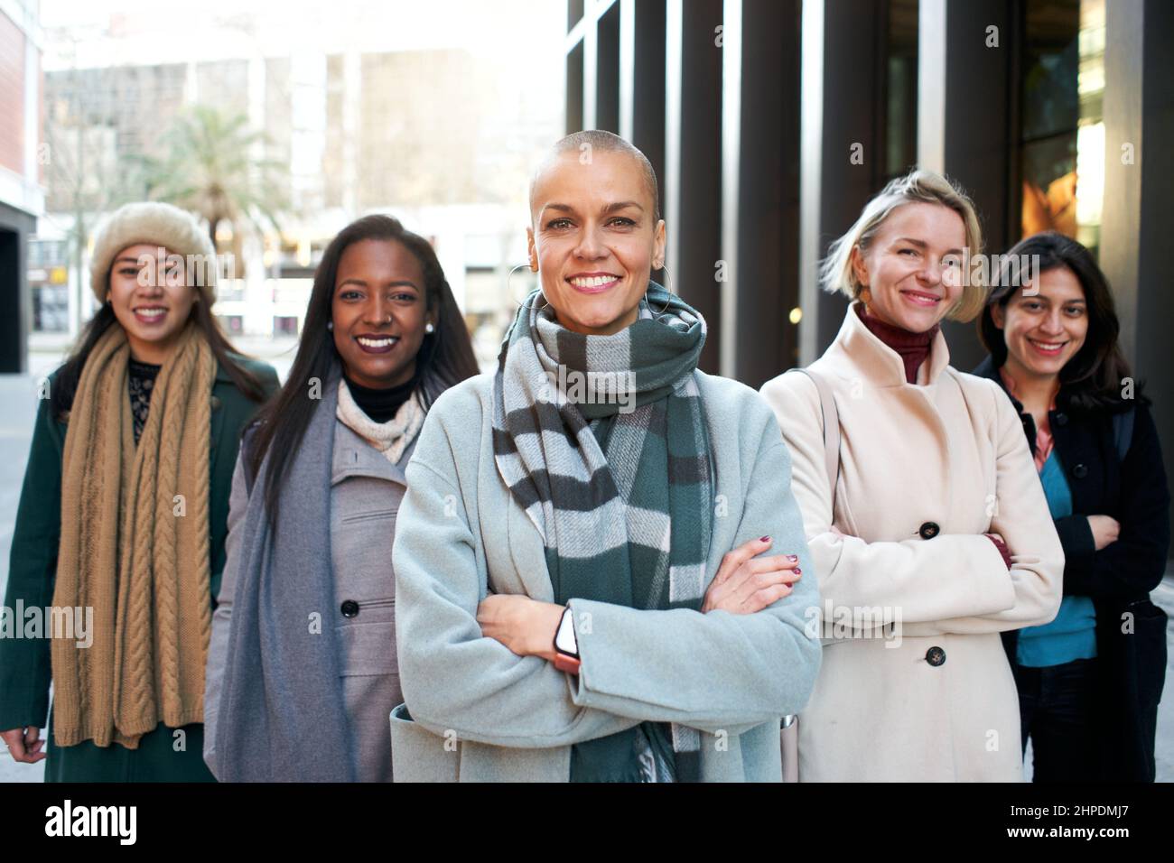 Fröhliches Porträt einer Gruppe weiblicher Geschäftsleute, die die Kamera betrachten. Nur Arbeiterinnen. Gruppe von Frauen, die mit Selbstvertrauen lächeln. Feministisch Stockfoto