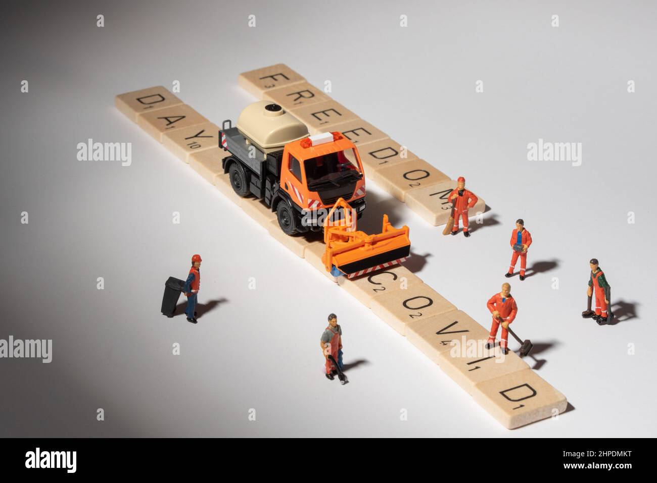 Miniaturfiguren, die die COVID-Straße reinigen, die Straße des Freiheitstages, die nach ihnen erscheint Stockfoto