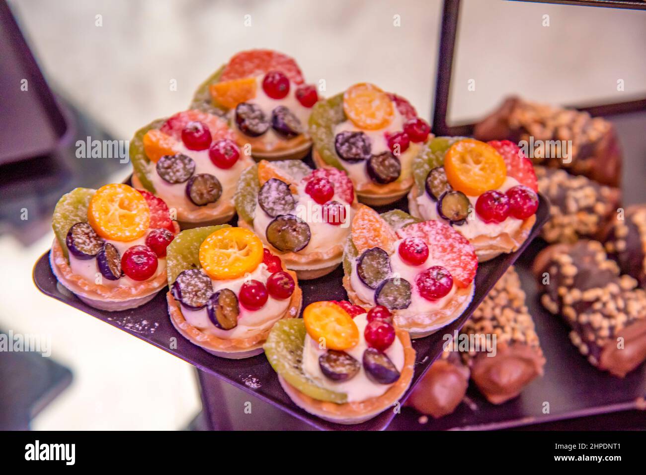 Verschiedene Cupcakes auf einem braunen Teller Stockfoto