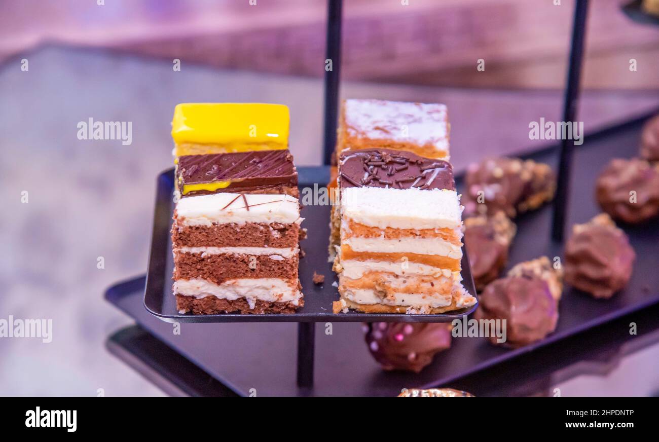 Verschiedene Cupcakes auf einem schwarzen Teller Stockfoto