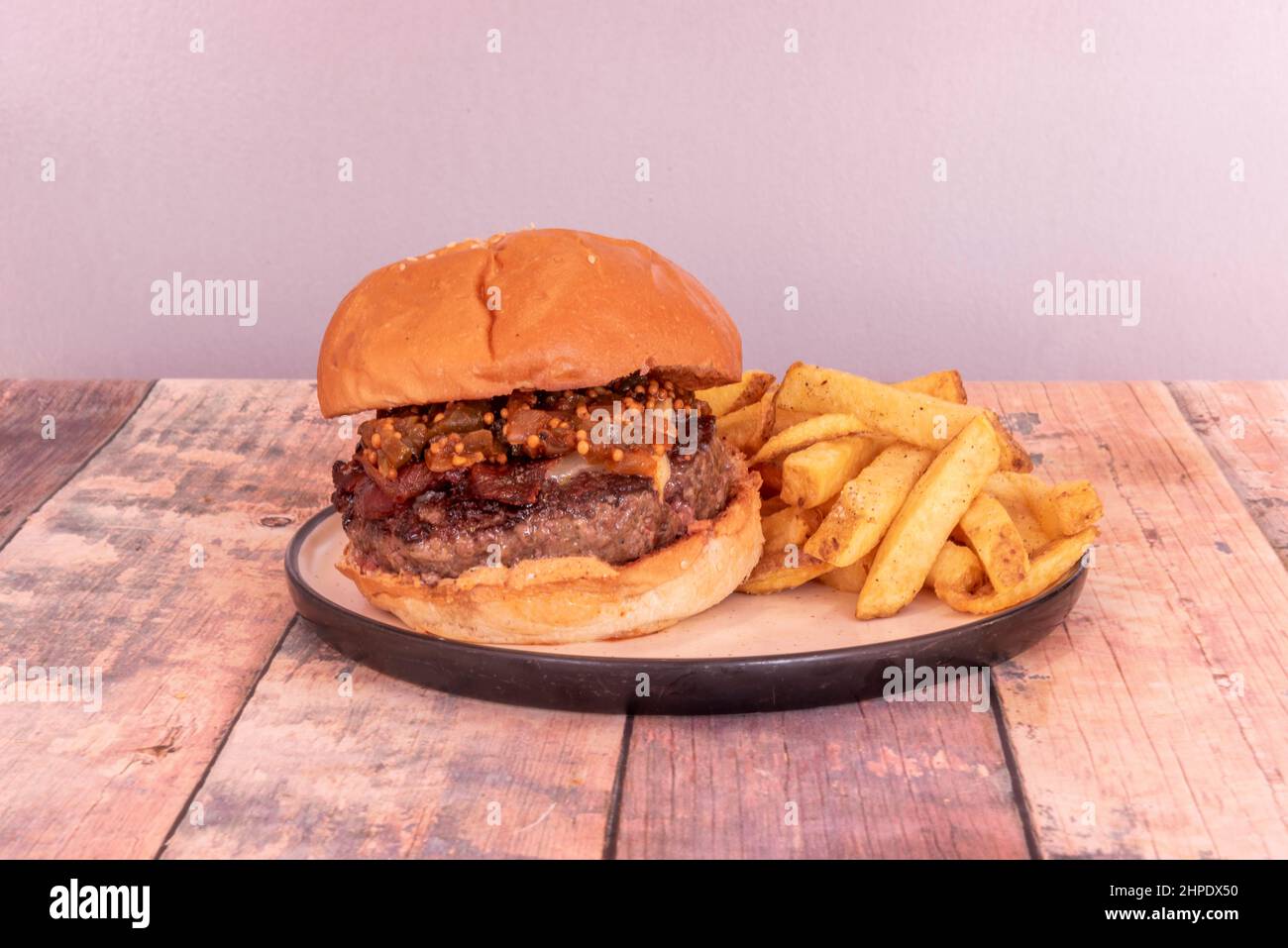 Rinderburger mit gebratenem Speck und Gemüseeintopf auf dem Fleisch mit hausgemachten Pommes frites Stockfoto