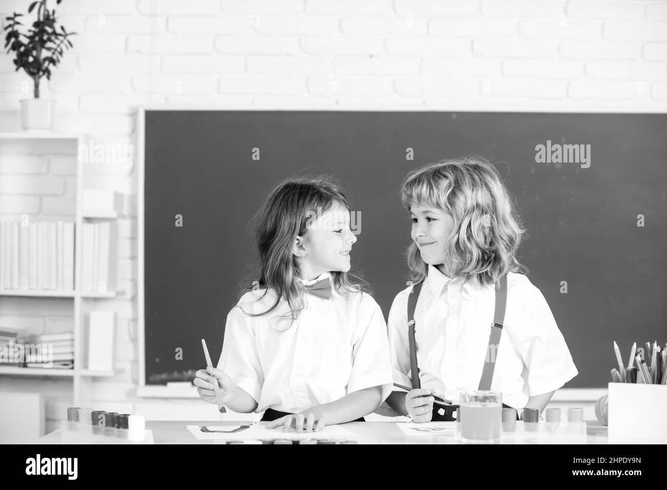 Kinder Mädchen und Junge Zeichnung mit Ausmalstiften. Nette Schulkinder malen in der Klasse in der Schule. Malunterricht, Zeichenkunst. Geschwister zeichnen mit Stockfoto