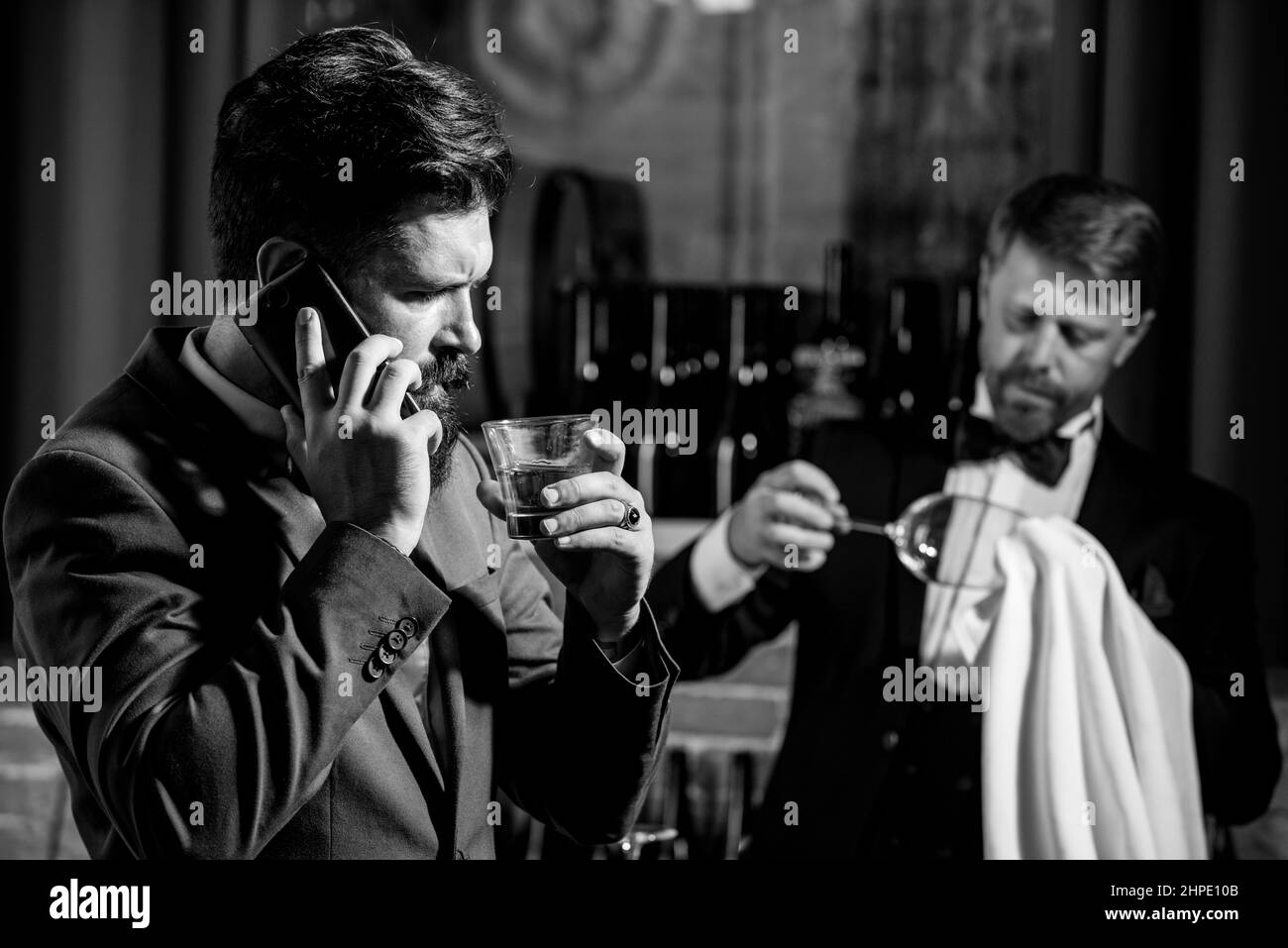 Gentlemans-Getränk. Whiskey im Glas. Bartending-Konzept. Barkeeper am Schalter. Hipster in der Bar. Stockfoto