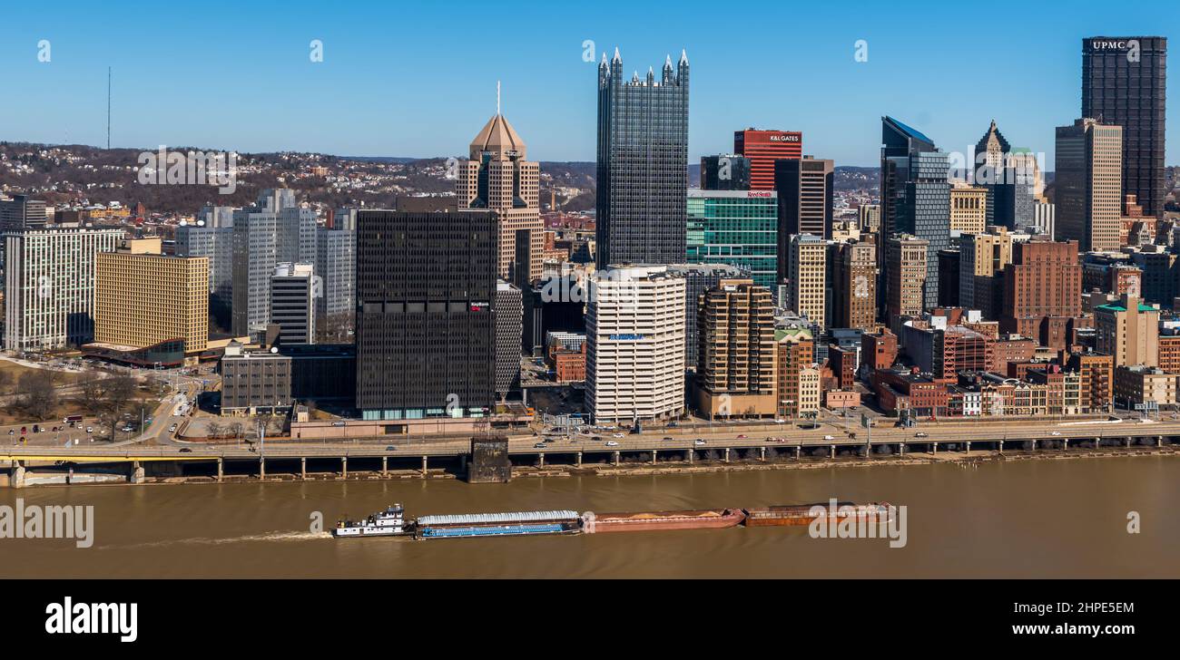 Ein Schleppboot schiebt vier Lastkähne auf einen schlammigen Monongahela River neben der Innenstadt von Pittsburgh, Pennsylvania, USA Stockfoto