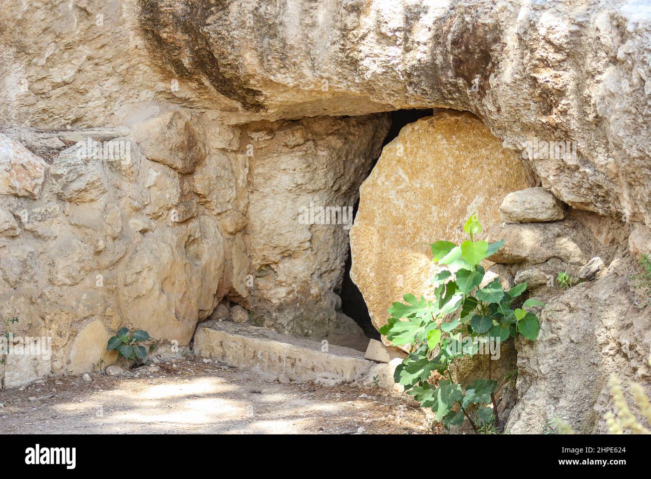 Ein Stein blockiert den Eintritt in eine Nachbildung des Grabes Jesu im Freilichtmuseum von Nazareth Village in Nazareth, Israel. Stockfoto