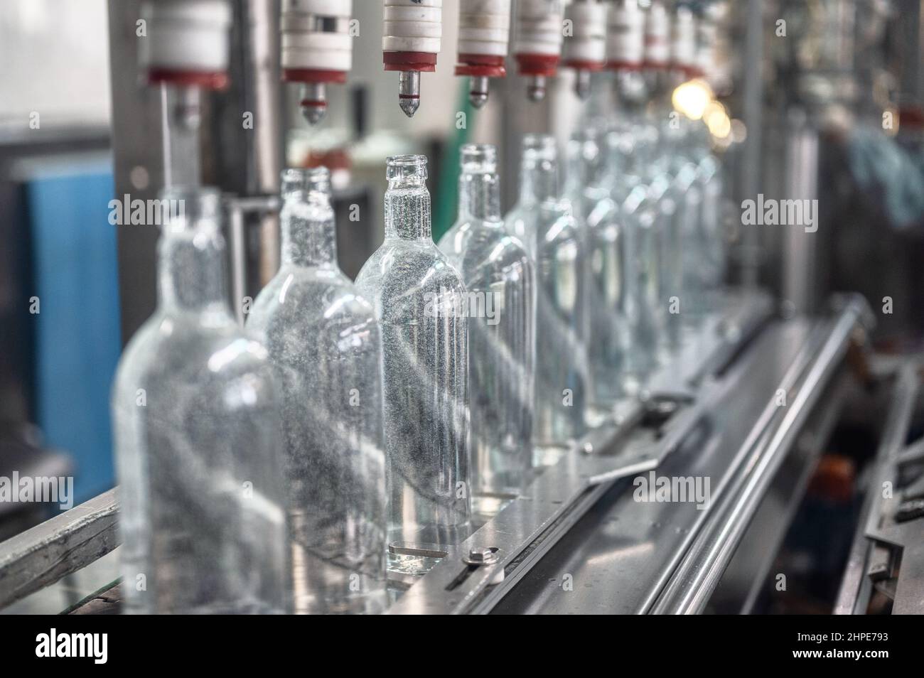Füllen von Glasflaschen mit Wodka-Getränk auf der Produktionslinie Stockfoto