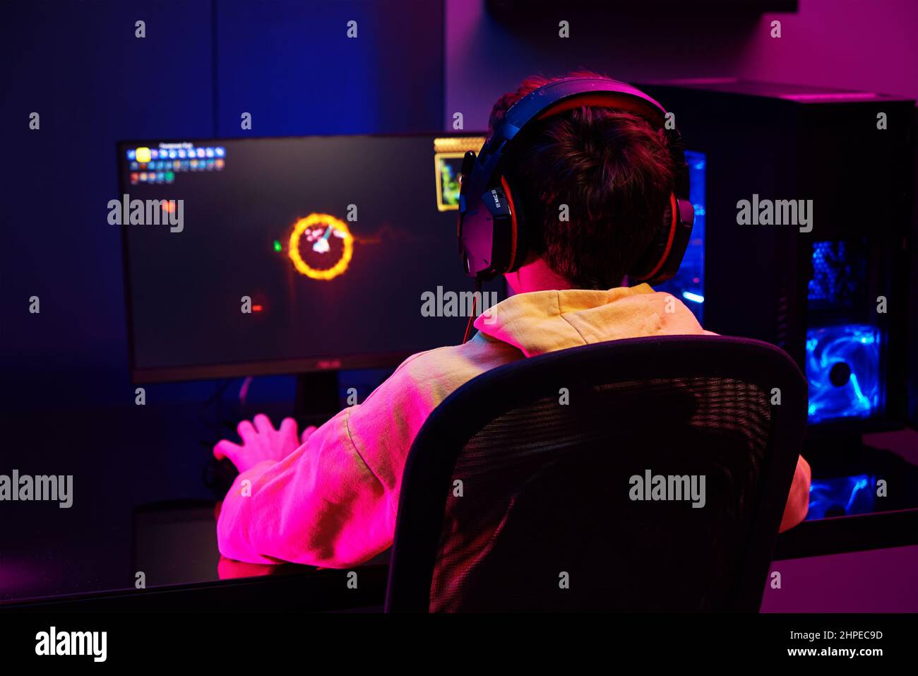 Teenager Junge spielen Computer-Videospiel im dunklen Raum, verwenden neonfarbene rgb mechanische Tastatur, Ort für Cybersport-Gaming Stockfoto