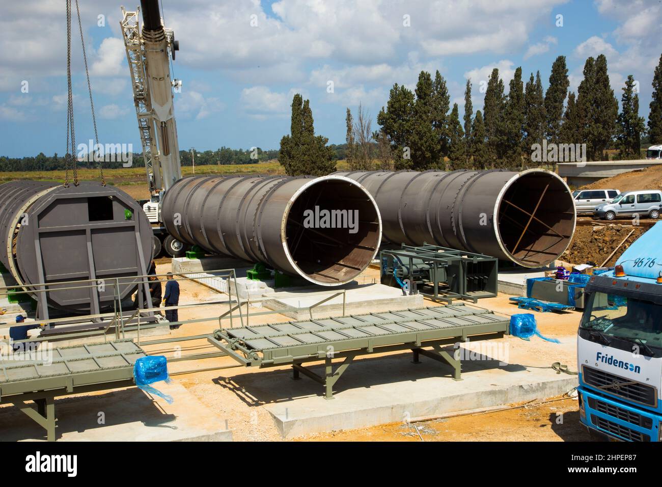 Krane und Rohre für den Transport von Wassertraktoren und Lastwagen bei Bauarbeiten in neuen Siedlungen in Israel Stockfoto