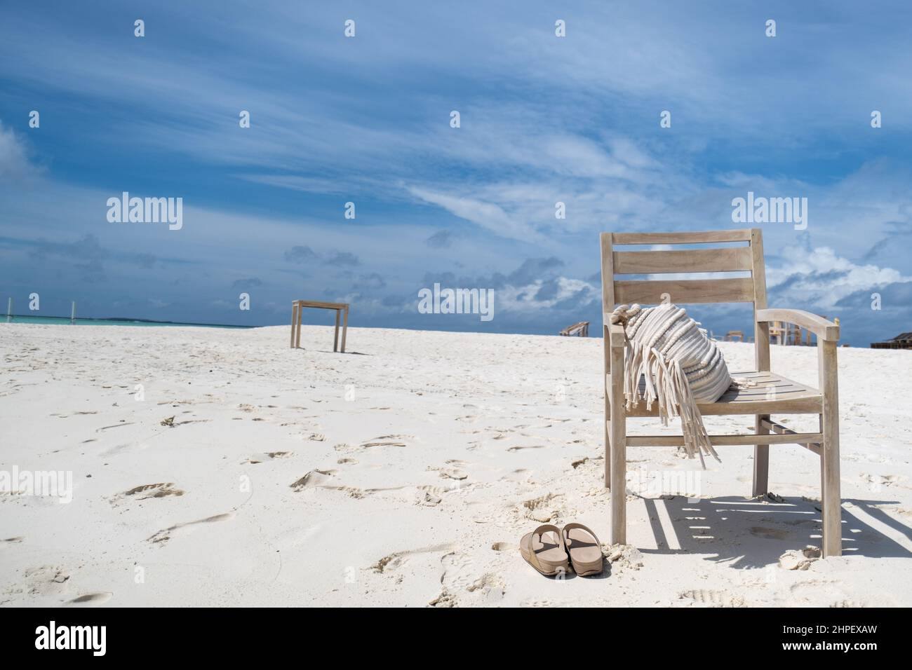 Maledivischer Blues - Szenen aus einem entspannten Urlaub auf den Malediven. Ein leerer Sessel über dem weißen Sandstrand auf den Malediven Stockfoto