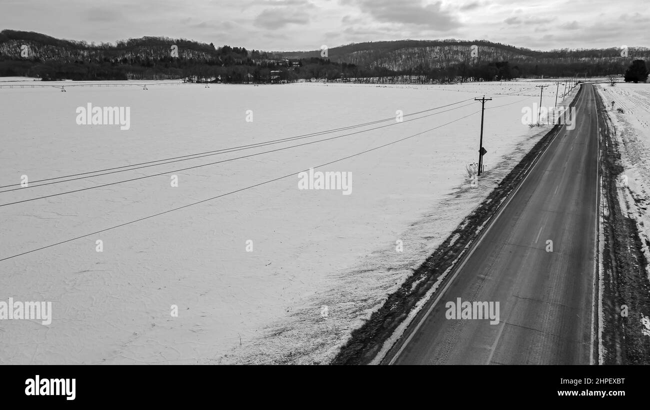 Schnee bedeckt das Land mit schneebedeckten landwirtschaftlichen Feldern Stockfoto