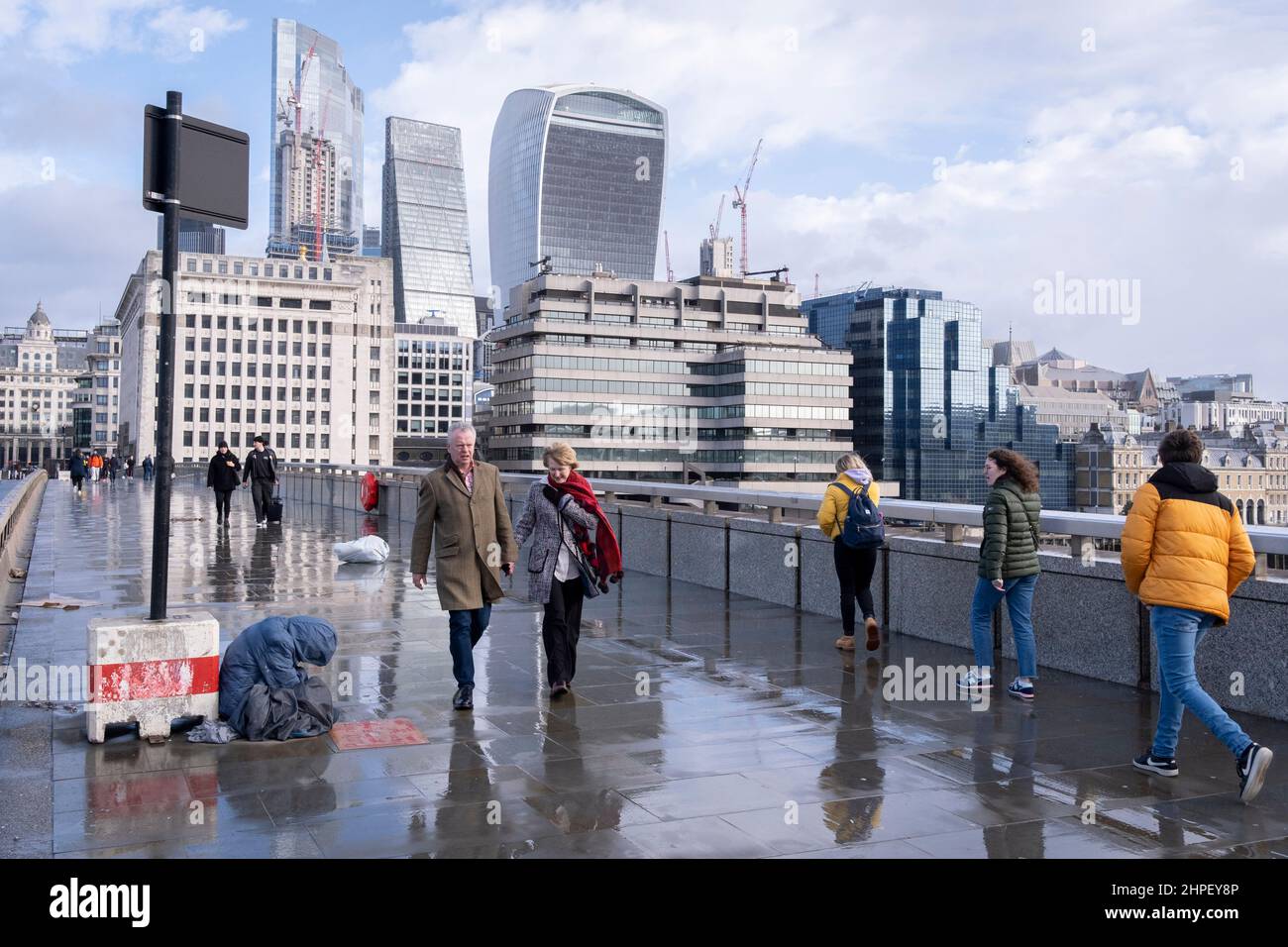 Pesestrier wandern über die London Bridge, während der Sturm Eunice über Südengland und Wales fegt und Orkanwinde am 18th. Februar 2022 in London, England, durch die City of London ziehen. Stockfoto