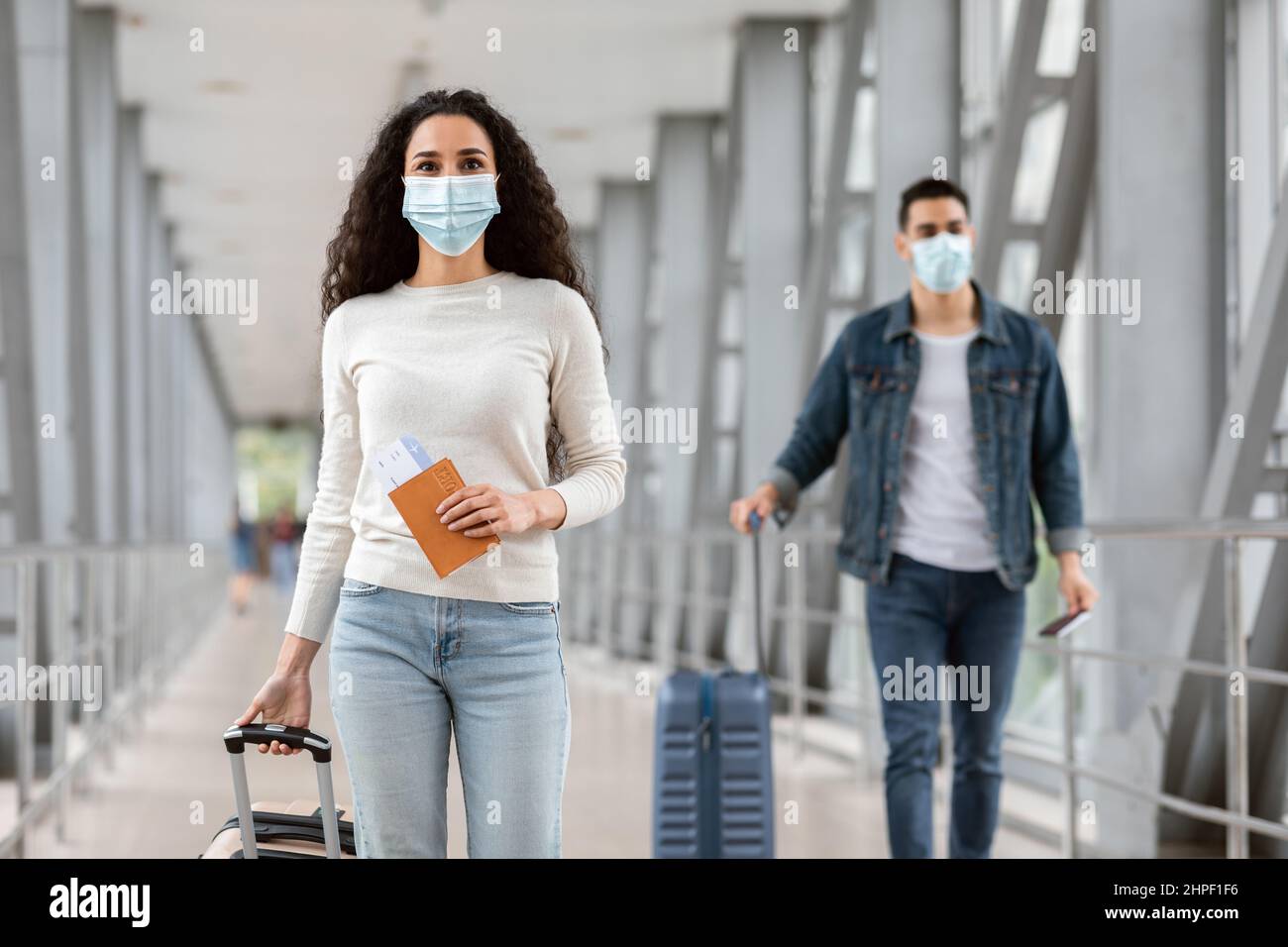 Neuer Normalwert. Junge Männer Und Frauen Mit Medizinischen Masken Gehen Am Flughafen Stockfoto