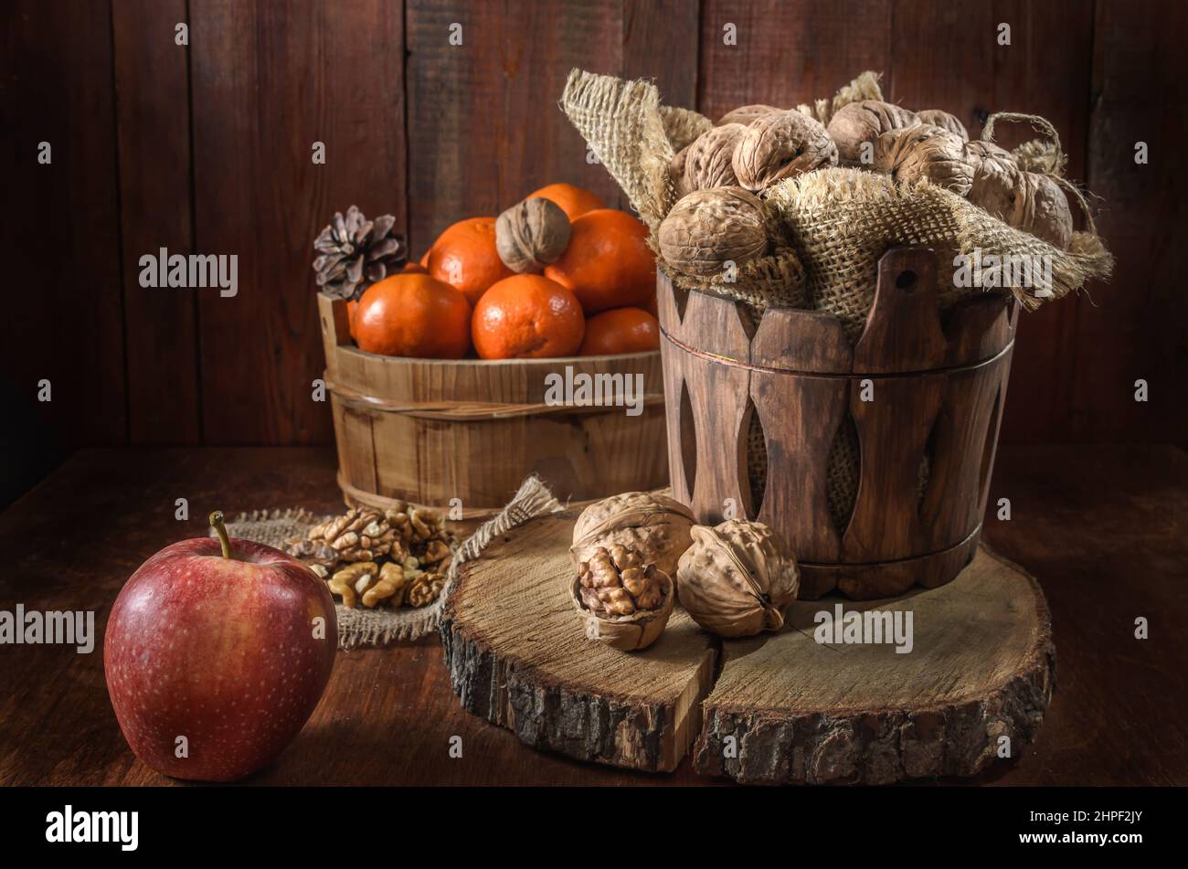 Walnüsse und andere Früchte auf dunklem Holzhintergrund Stockfoto