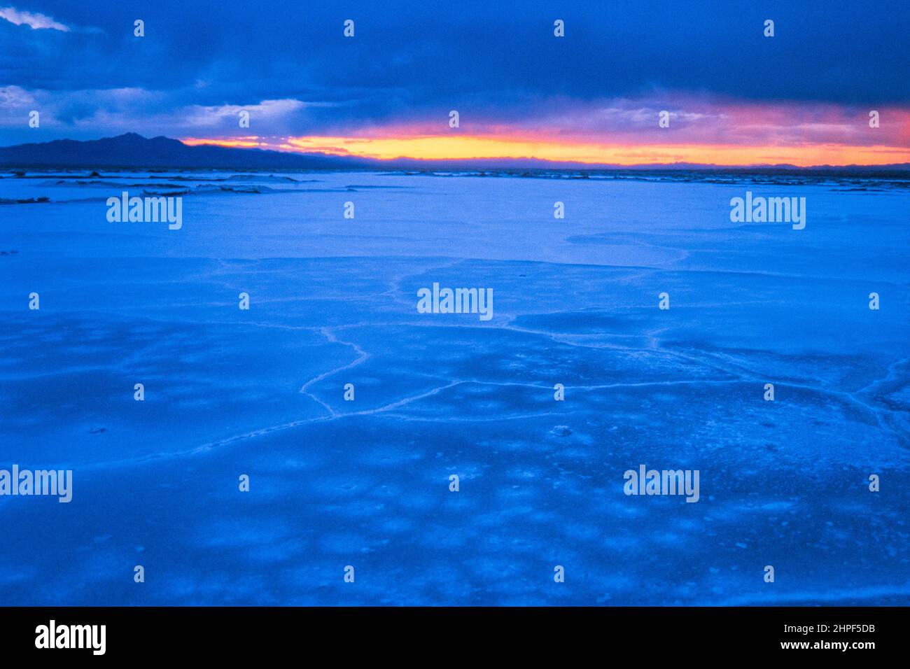 Stürmischer Himmel bei Sonnenuntergang über den Mineralvorkommen des trockenen Seebetts des Bristol Lake in der Mojave-Wüste in der Nähe von Amboy, Kalifornien. Stockfoto