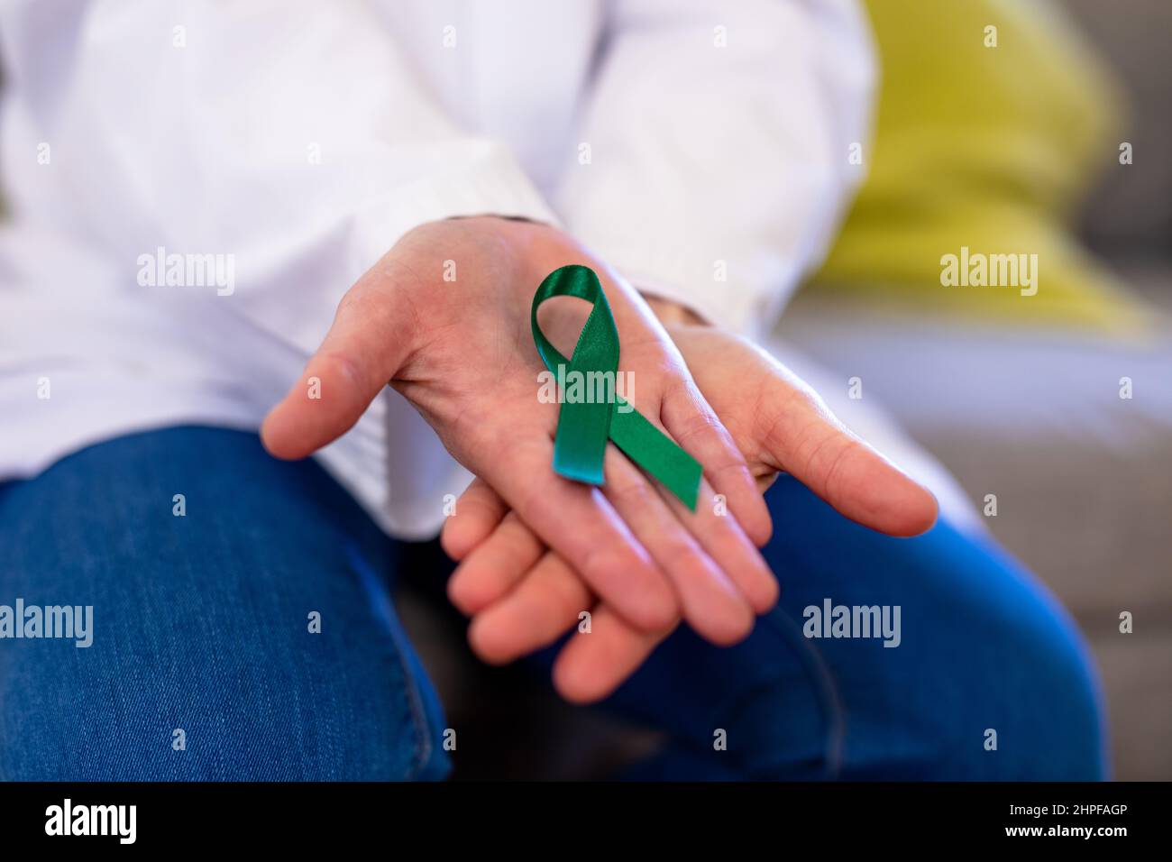 Mittelteil einer reifen kaukasischen Ärztin mit einem Band zur Sensibilisierung für die psychische Gesundheit Stockfoto