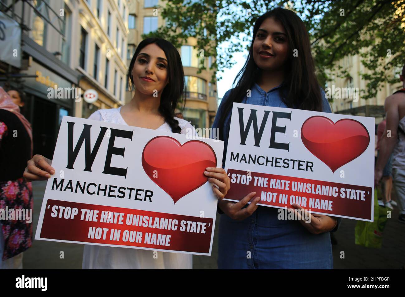 Junge Frauen posieren für die Kamera mit einem We Love Manchester-Schild nach dem Bombenanschlag im Jahr 2017. Stockfoto