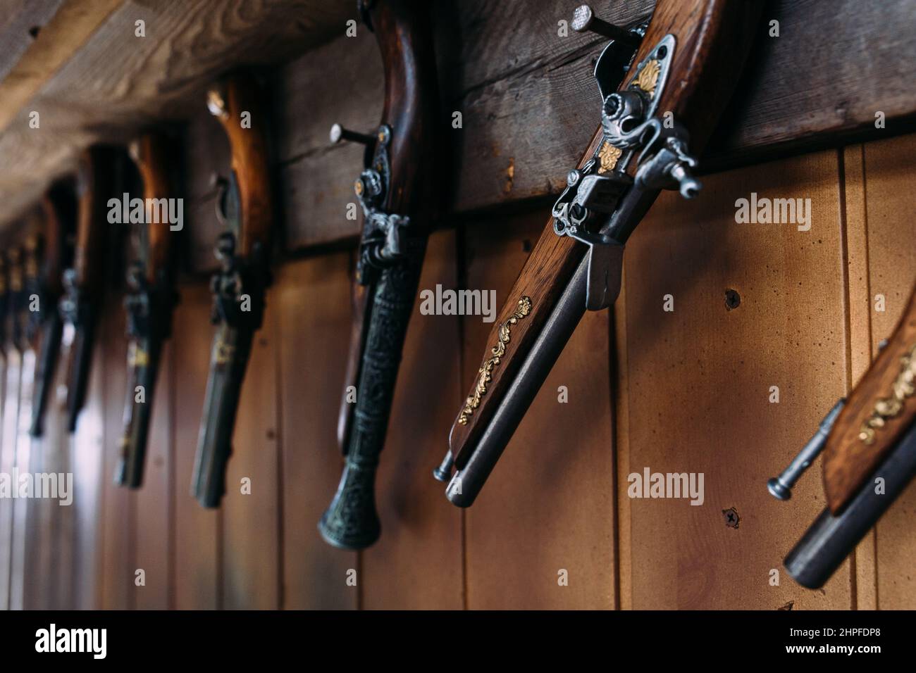 Eine Reihe alter Pistolen im Regal eines Geschenkeladens. Mittelalterliche Waffen. Stockfoto