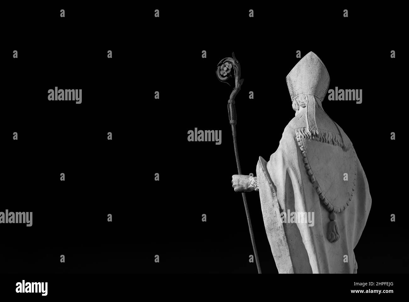 Katholische Kirche. Bischof mit Mitra und Bischofsstab, eine alte Statue aus weißem Marmor auf alten Mauern von Lucca, errichtet im 17th. Jahrhundert (Schwarz-Weiß mit Kopie Stockfoto