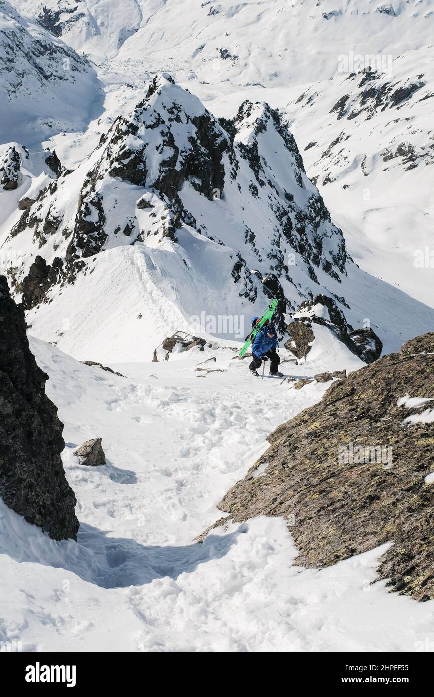 Skifahrer klettern an der arête in Richtung Pointe Alphonse Favre, Naturschutzgebiet Aiguilles Rouges, Chamonix, Frankreich Stockfoto