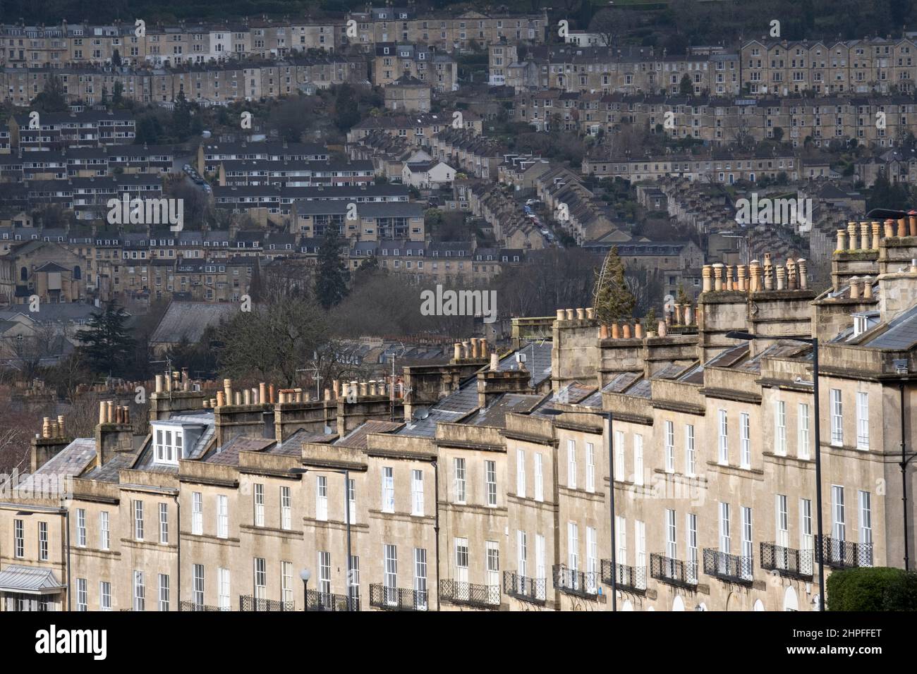 Von Bathwick Hill aus gesehen, sind Reihenhäuser im Vordergrund am Dunsford Place auf Bathwick Hill und in der Ferne ein Stadtbild von Hanggrundstücken rund um die Stadt Bath, am 19th. Februar 2022, in Bath, England. Die Kurstadt Bath war in der römischen Zeit als Aquae Sulis ('die Wasser von Sulis' c. 60 n. Chr.) und im Jahr 2019 waren es 101.106 Einwohner. Stockfoto