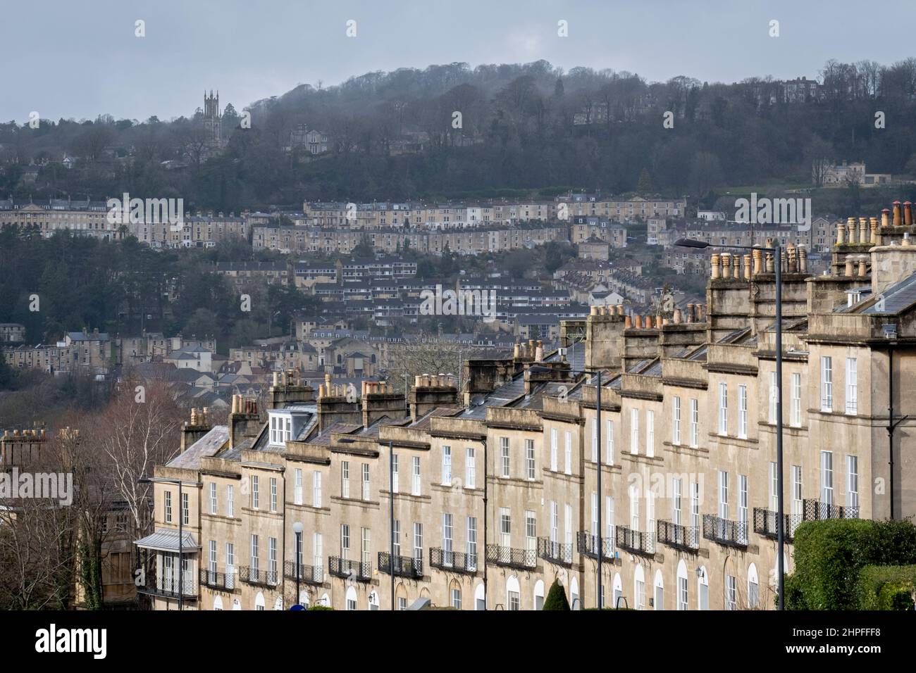 Von Bathwick Hill aus gesehen, sind Reihenhäuser im Vordergrund am Dunsford Place auf Bathwick Hill und in der Ferne ein Stadtbild von Hanggrundstücken rund um die Stadt Bath, am 19th. Februar 2022, in Bath, England. Die Kurstadt Bath war in der römischen Zeit als Aquae Sulis ('die Wasser von Sulis' c. 60 n. Chr.) und im Jahr 2019 waren es 101.106 Einwohner. Stockfoto