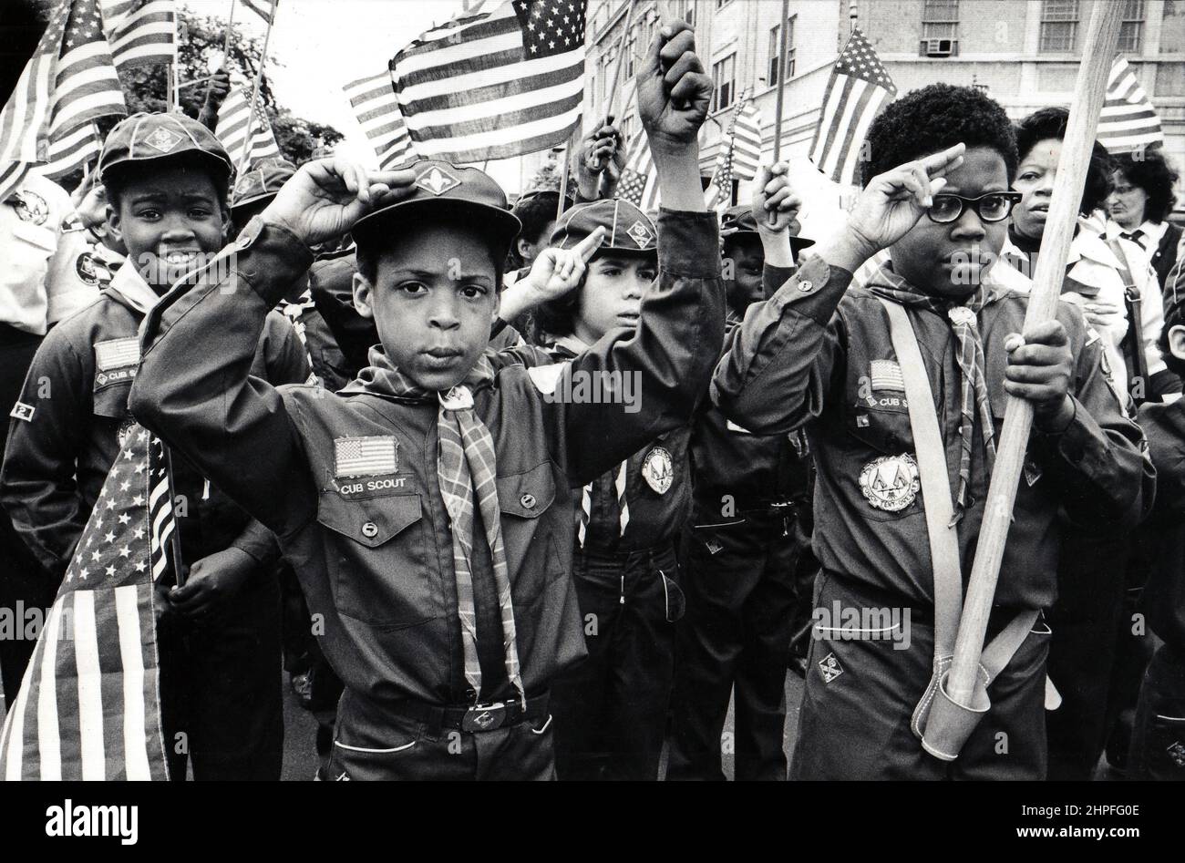 Inmitten eines Meeres von Flaggen grüßen patriotische Cub Scouts mit 3 Fingern. Bei einer Veteran's Day Parade in Manhattan, New York um 1976. Stockfoto