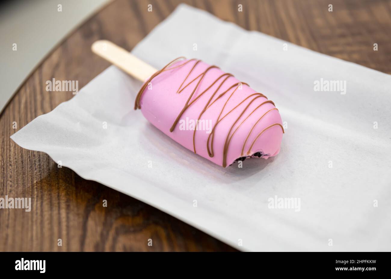 Mousse Dessert in Form von Eis mit Eis bedeckt mit rosa Schokolade. Stockfoto