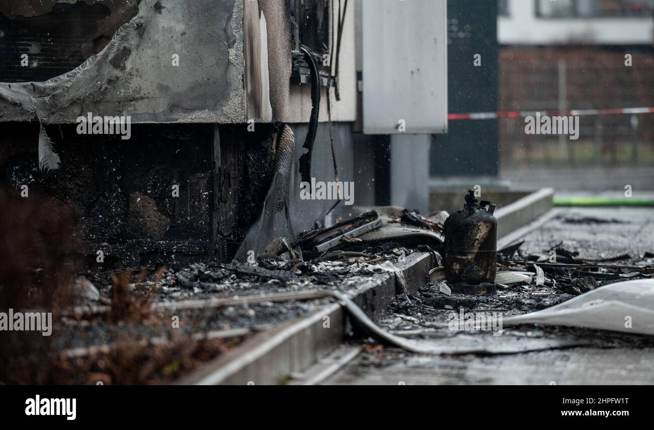 Essen, Deutschland. 21st. Februar 2022. Eine Gasflasche steht zwischen Trümmern im Apartmentkomplex. Im westlichen Stadtteil der Stadt ist seit dem frühen Montagmorgen ein ganzer Apartmentblock in Flammen aufgegangen. Das Feuer war kurz nach Mitternacht in der Bargmannstraße ausgebrochen. Die Flammen breiten sich schnell über mehrere Stockwerke aus. Es ist noch unklar, ob Menschen verletzt wurden. Quelle: Fabian Strauch/dpa/Alamy Live News Stockfoto