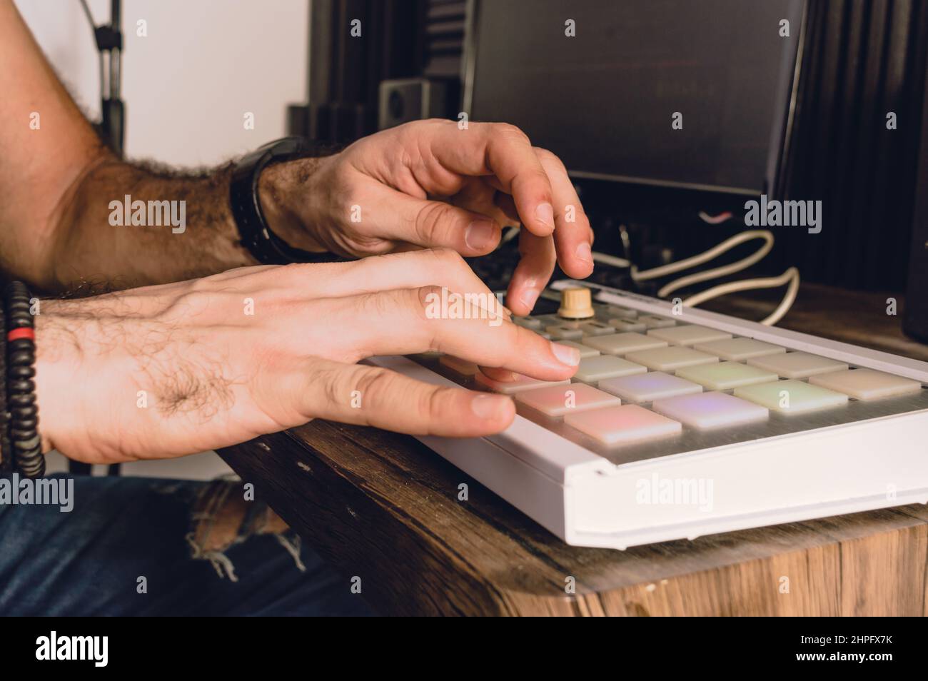 Kaukasische Hände, die einen Midi-Controller in einem Heimstudio verwenden, um urbane Musik zu schlagen, Musikindustrie und Produktionskonzept zu schaffen. Stockfoto