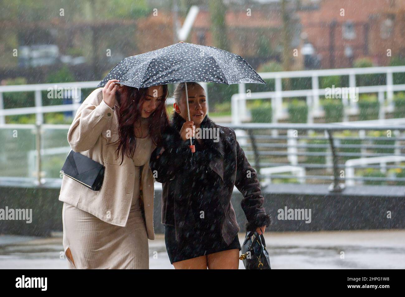 Ascot, Bergen, Großbritannien. 19th. Februar 2022. Racegoers, die am Betfair Ascot Chase Raceday teilnehmen, hatten heute nach dem Sturm Eunice bei starkem Wind und starkem Regen Probleme, ihre Regenschirme zu halten. Quelle: Maureen McLean/Alamy Stockfoto