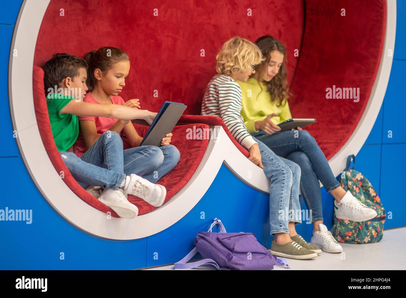 Mädchen und Jungen, die sich für Tablets interessieren Stockfoto