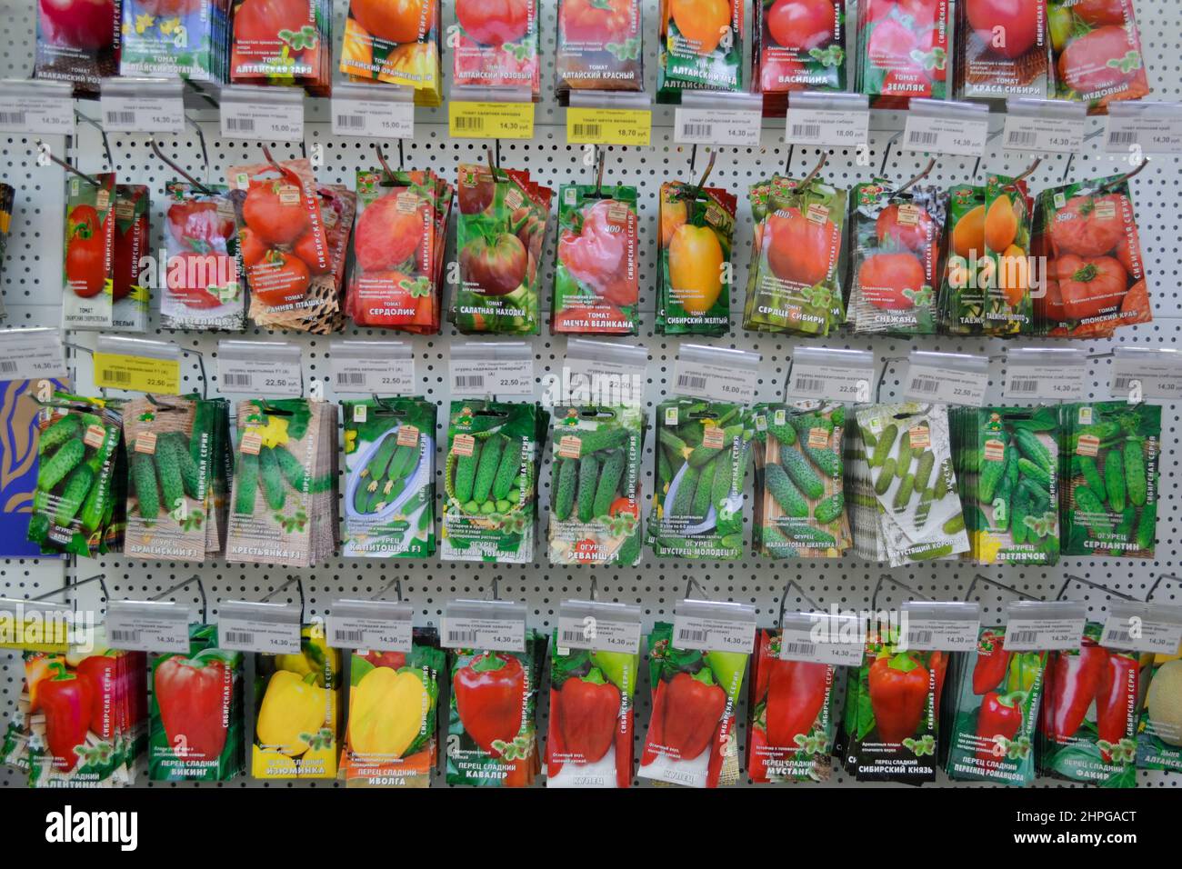 Moskau, Russland, Dezember 2019: Nahaufnahme eines Stands mit Papiertüten mit Gemüsesamen: Tomaten, Gurken, Paprika. Verkauf im Laden. Stockfoto