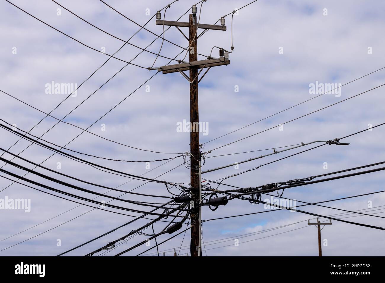 Strommast mit vielen elektrischen Kabeln. Komplexes Stromnetz Holzmasten verbinden und verteilen Strom- und TV-Signale Stockfoto