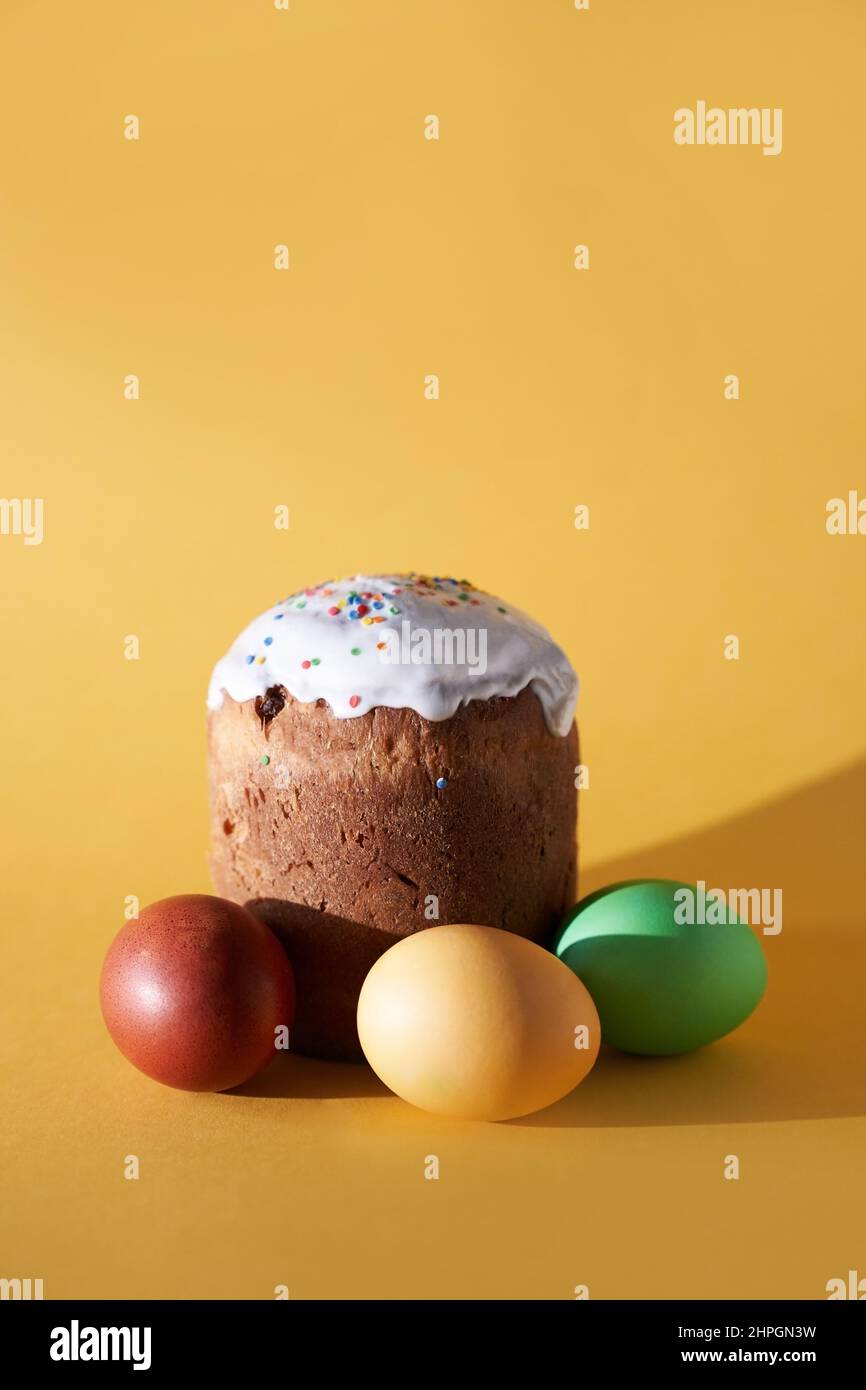 Nahaufnahme von farbigen Ostereiern und kulich auf gelbem Hintergrund. Mit einem zu kopierenden Leerzeichen. Hochwertige Fotos Stockfoto