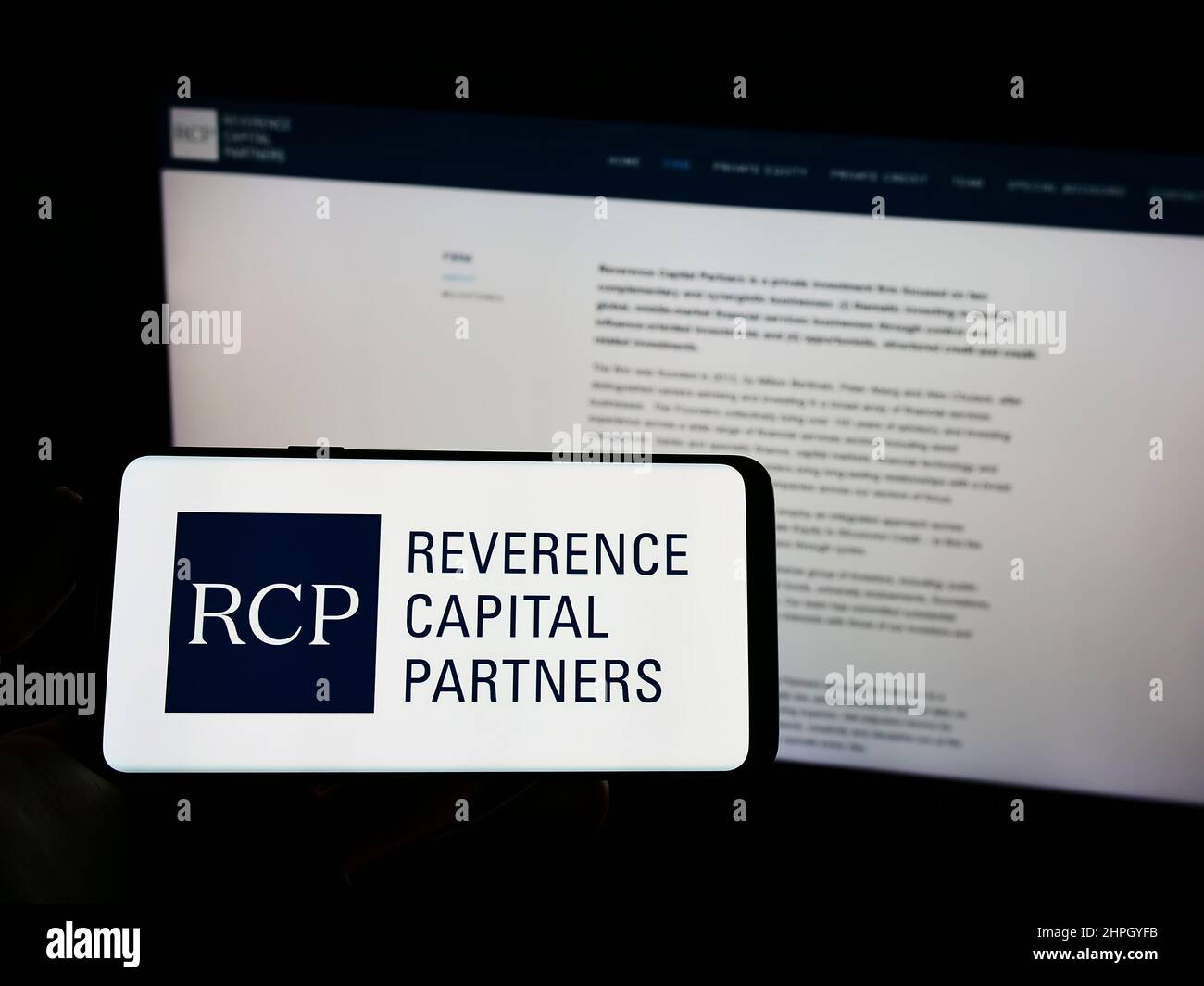 Person mit Mobiltelefon und Logo des US-amerikanischen Unternehmens Reverence Capital Partners LP (RCP) auf dem Bildschirm vor der Webseite. Konzentrieren Sie sich auf die Telefonanzeige. Stockfoto